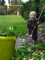 Papa helpen in de tuin: alle blaadjes samenbrengen